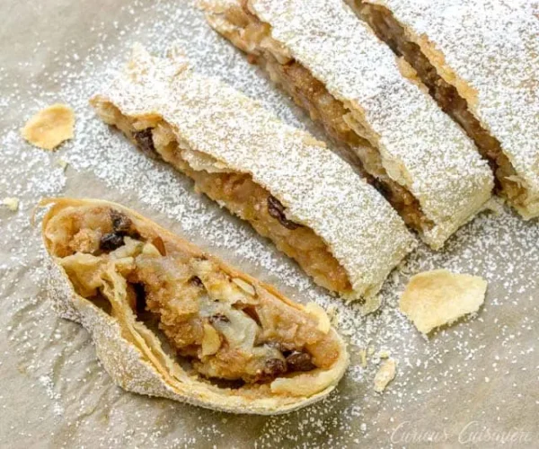 Austrian Apple Strudel Slice (Apfelstrudel) - Authentic Pastry With Flaky Layers, Filled With Apples, Raisins, And Cinnamon