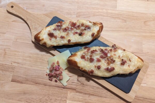 This Picture Showes Two Bretzel Stick Canada Topped With Cheese And Bacon