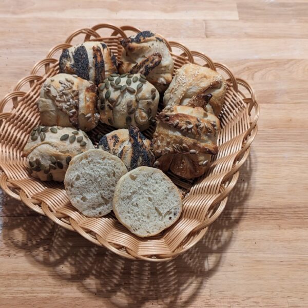 This picture showes franconia buns with different sort of seeds in a basket such as sesame, sunflower, pumpkin and poppy seeds