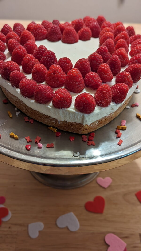 Creamy Raspberry Heart 08 This Picture Shows The Creamy Raspberry Heart Cake 08 From Front With Sprinkles On Plate