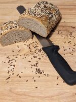 this picture shows the oil seed bread cut in half with a knife underneath