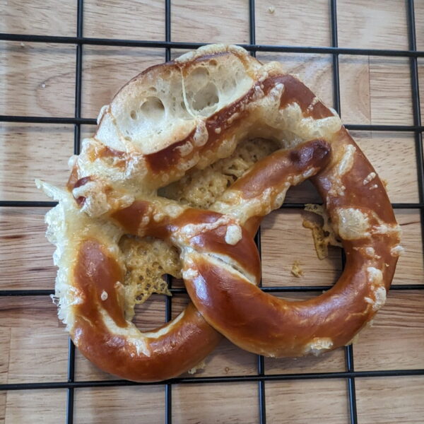 Hand-twisted Bavarian bretzel cheese with melted Emmental cheese—fresh, golden, and absolutely irresistible