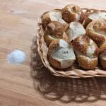 a basket of bretzel buns and knots on a table