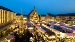 Crowds at Nuremberg's Christkindlesmarkt in front of the Church of Our Lady – festive lights, wooden booths, and a magical holiday atmosphere