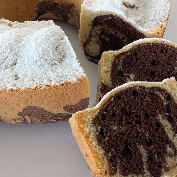 A sliced piece of German marble cake (Marmorkuchen) showing the detailed chocolate and vanilla swirl pattern inside.